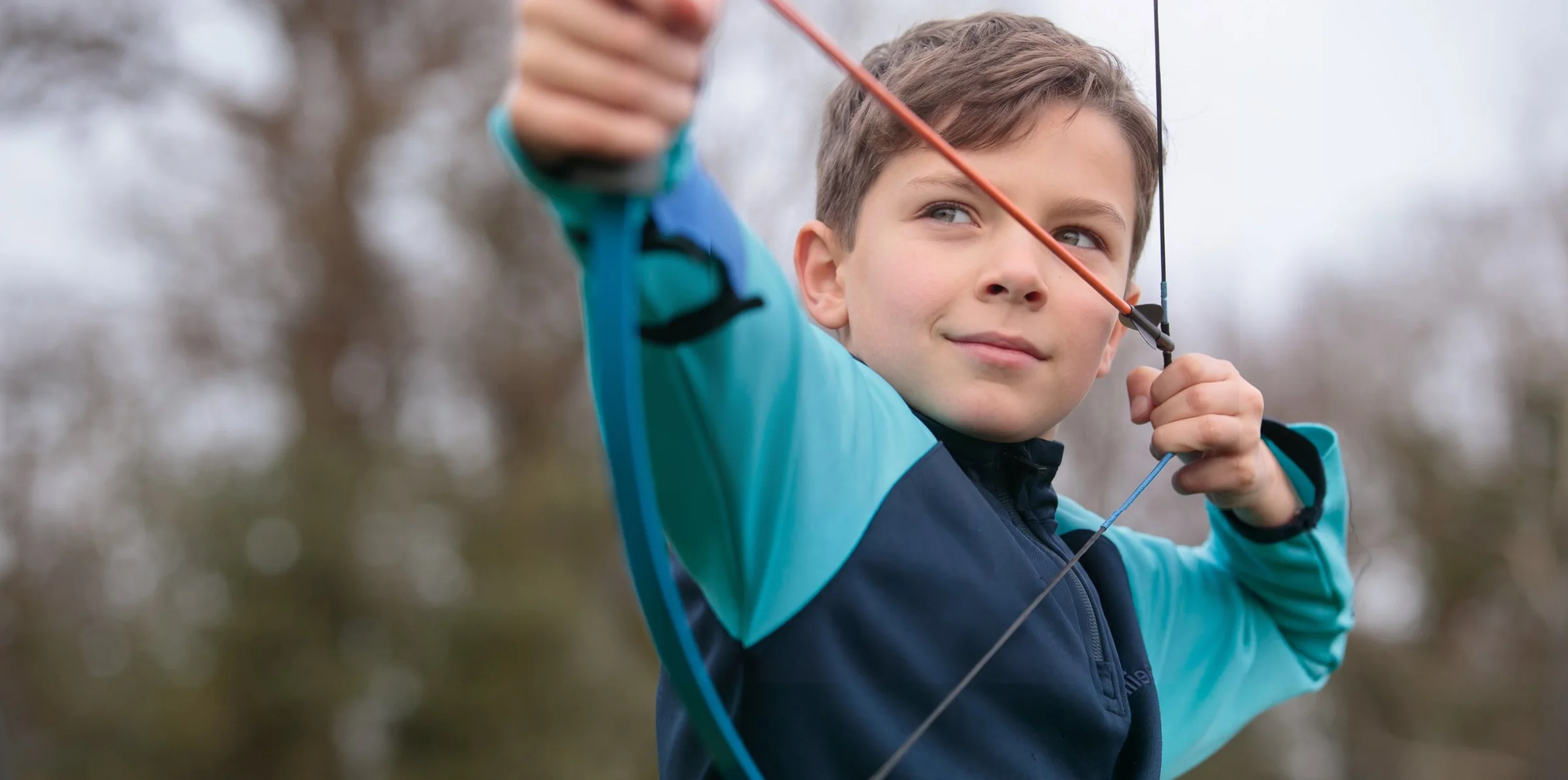 A boy draws his bow and takes aim during an archery lesson