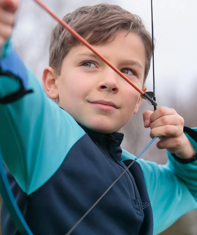 A boy draws his bow and takes aim during an archery lesson